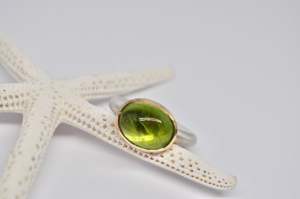 Silver and gold ring with peridot cabochon