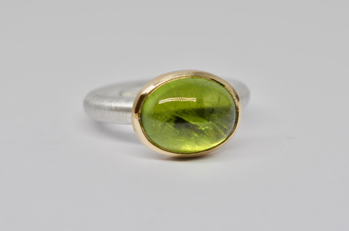 Silver and gold ring with peridot cabochon