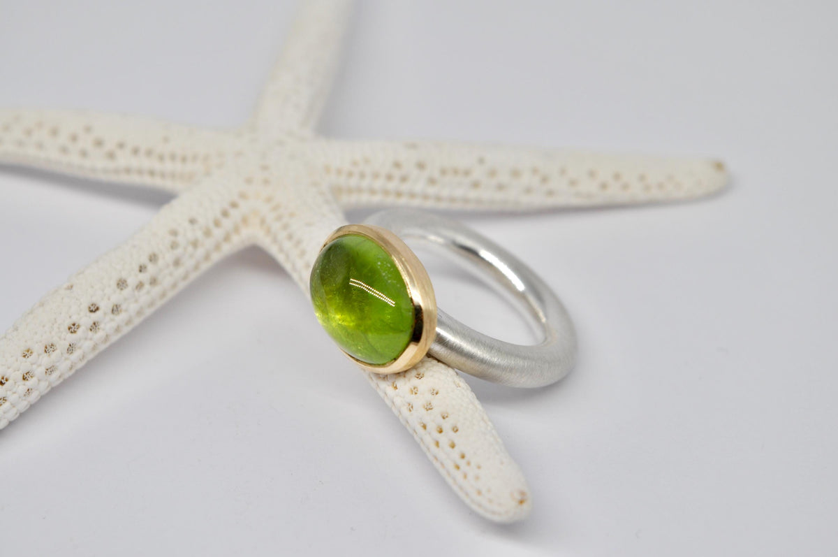 Silver and gold ring with peridot cabochon