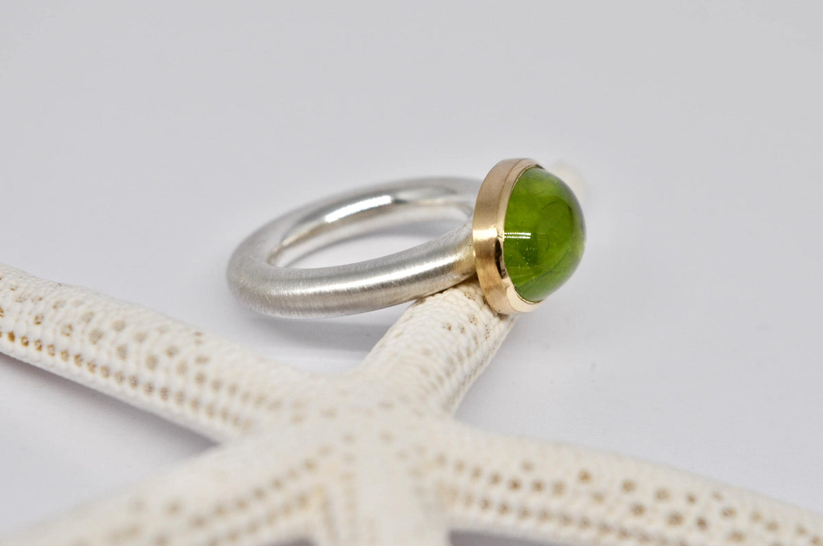 Silver and gold ring with peridot cabochon